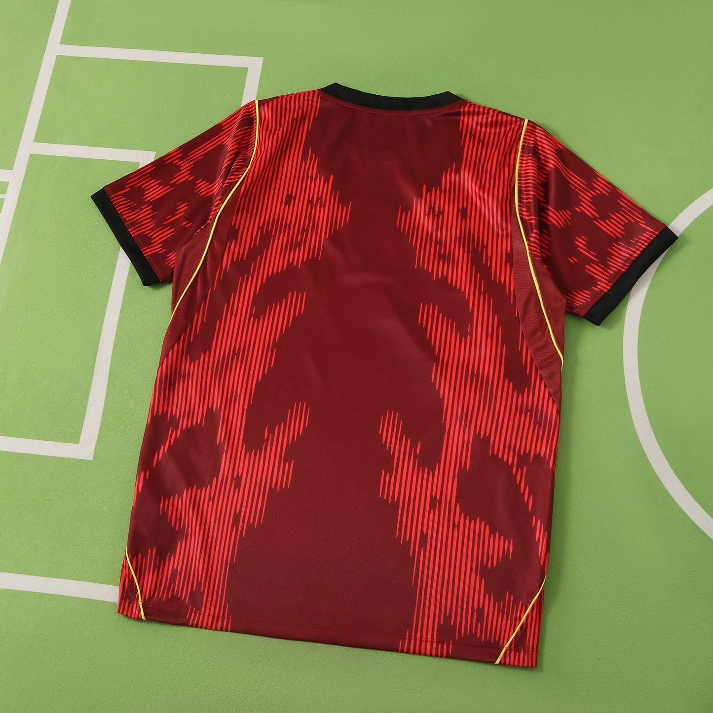 Red sports brazil jersey with black patterns on a green field background