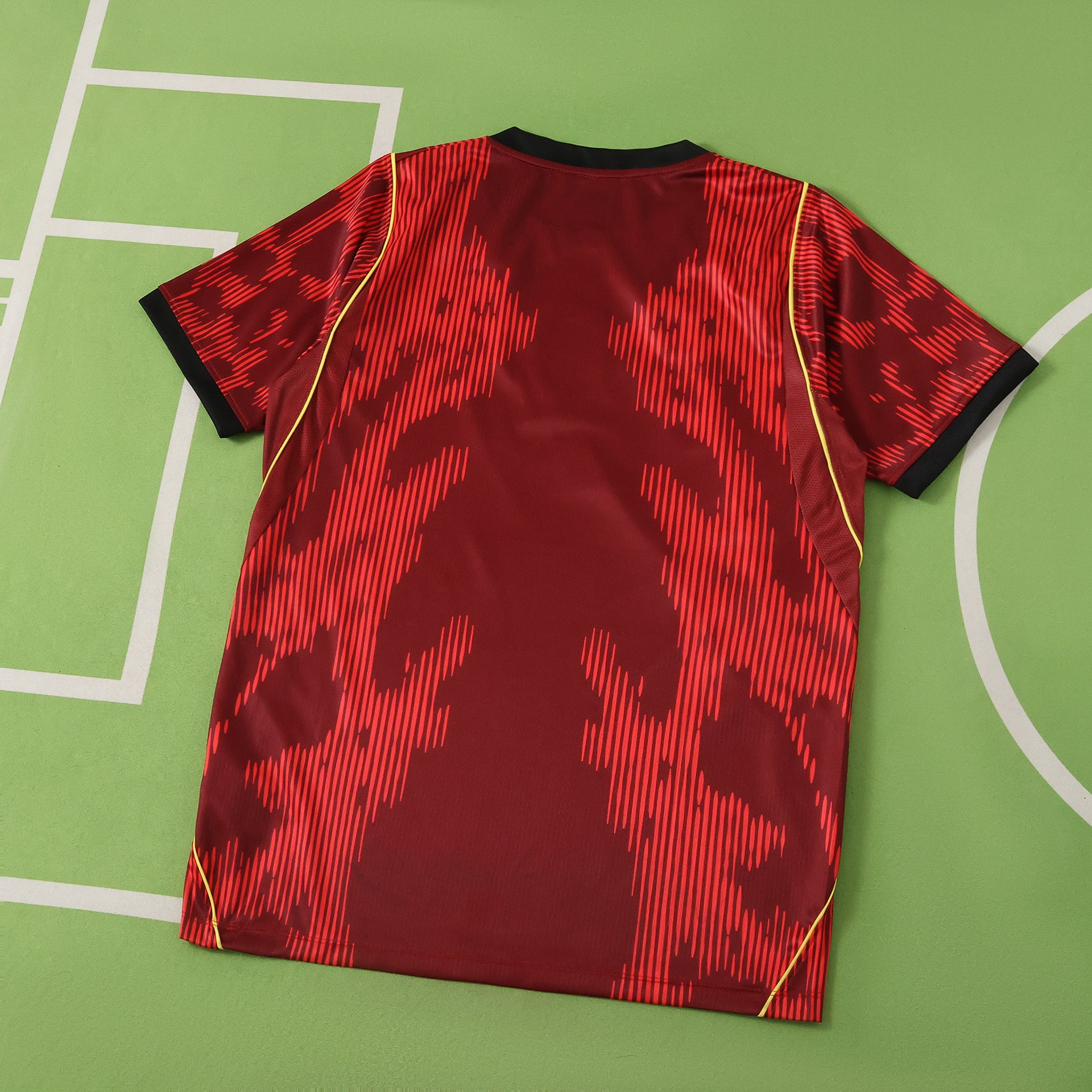 Red sports brazil jersey with black patterns on a green field background